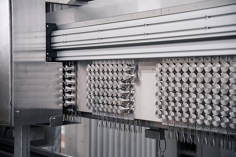 The image shows an advanced dosing system with a variety of metal components and a clear, structured arrangement.