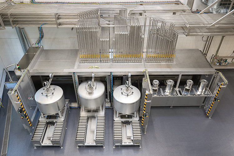 Eine moderne Dosieranlage mit mehreren großen Behältern und einem komplexen Rohrleitungssystem im Hintergrund.