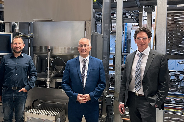 Die Gruppe von vier Männern steht lächelnd vor der FRICKE-Multiplex-Anlage in Minden.