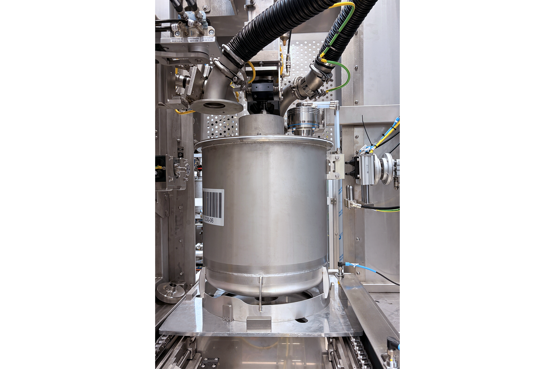 Der Edelstahlbehälter ist auf einer Plattform montiert, mit einem Barcode sichtbar und verschiedenen Anschlüssen für Maschinen.