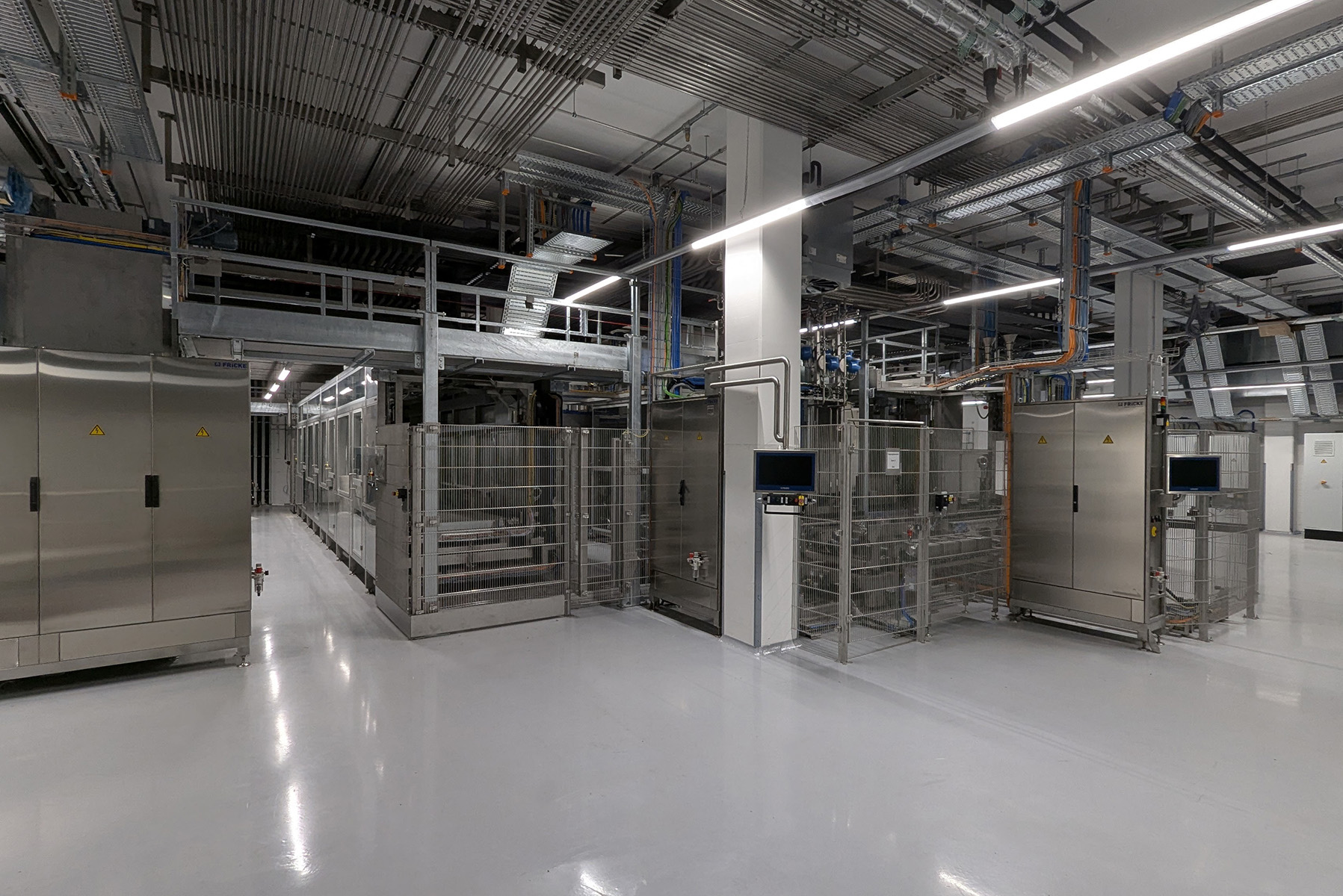 Der Raum zeigt eine hochmoderne Fertigungsanlage mit verschiedenen Geräten, die für präzise Dosierung und Füllung ausgelegt sind.