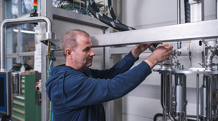 The technician checks and repairs a dosing unit to ensure that the machines are working efficiently.